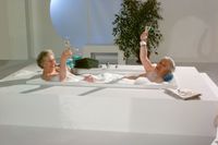 Alter Mann und Frau in Badewanne mit Sekt